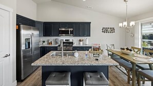 A modern kitchen with dark cabinets, stainless steel appliances, and a granite countertop. - New house!! Outdoor Hot tub with beautiful sunset views (Kennewick)