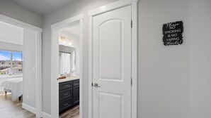 A bedroom with a large window, a bed, a dresser, and a mirror. - New house!! Outdoor Hot tub with beautiful sunset views (Kennewick)