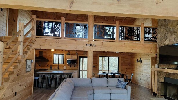 A spacious cabin interior with a large living area, a kitchen, and a dining area.