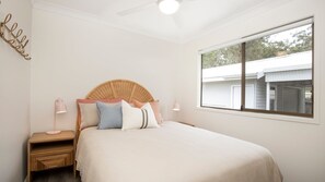 A bedroom with a bed, bedside tables, and a window. - Hanalei - Pet Friendly - Directly Opposite Waterfront (Myola)