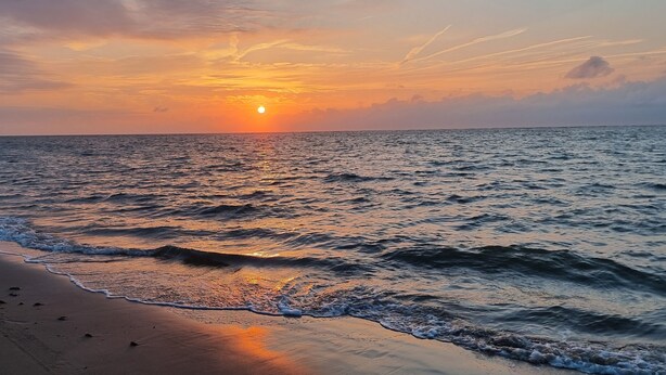 A beach with waves at sunset. - Impeccable Studio in Ouddorp 400m from th (Ouddorp)
