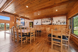 A wooden interior with a dining area, benches, and artwork on the walls.
