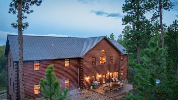 A log cabin with a fire pit and outdoor seating area.
