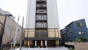 A modern multi-story hotel with a central entrance, multiple balconies, and a flat facade. - HOTEL GLANY's KOSHIGAYA premier (Koshigaya)