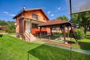 A two-story house with a covered patio and a small garden.