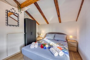 A bedroom with a bed, a wardrobe, a mirror, and a radiator.