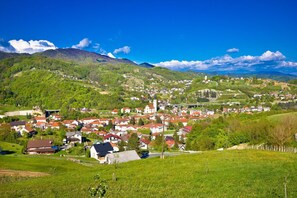 Une ville qui se distingue par son église imposante, entourée de collines verdoyantes et surplombée par un ciel dégagé.