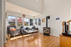 A spacious living room with a fireplace, a sofa, a coffee table, and a television.