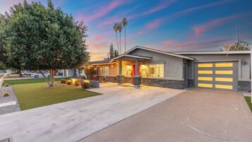 A modern two-story house with a garage, a driveway, and a well-maintained lawn.