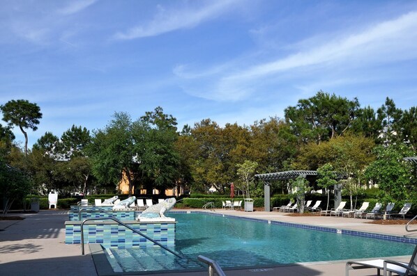 A pool area with lounge chairs and a pergola.