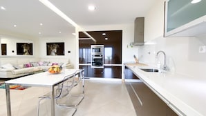 A modern kitchen with a central island, stainless steel appliances, and a large window. - Luxury condominium apartment with swimming pool (Lagos)