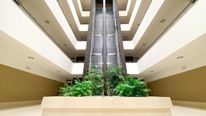 A modern building with a central atrium, multiple floors, and a staircase leading to the upper levels. - Luxury condominium apartment with swimming pool (Lagos)