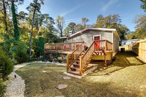 A single-story cabin with a wooden deck and a staircase leading to a red door. - Step-Free Home w/ Fire Pit - 3 Miles to USC! (Columbia)