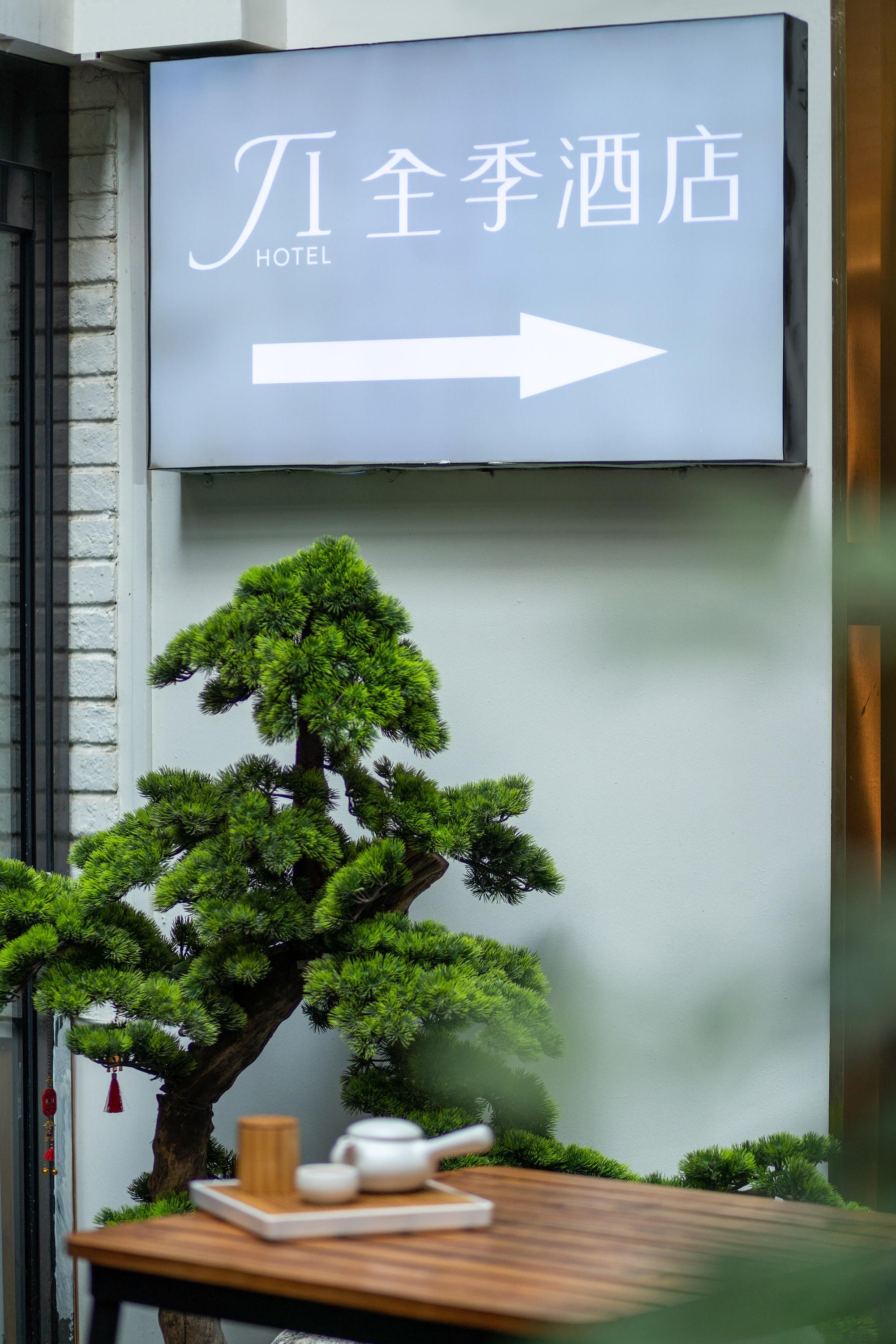 A sign for Ji Ji Hotel with an arrow pointing to the right.