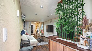 A modern living room with a sofa, a coffee table, and a decorative cabinet. - miyu Ebisu Independent Japanese hotel (Osaka)