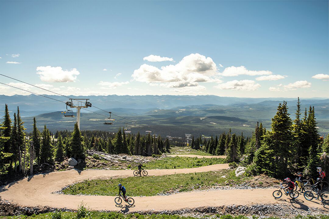 A mountain biking trail with a ski lift in the background.