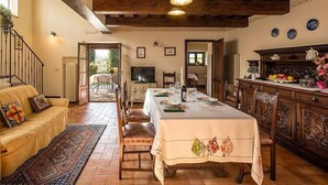 A dining area with a long table, chairs, and a wooden ceiling.