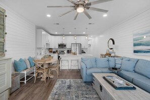 A modern kitchen with white cabinetry, a central island, and a ceiling fan.