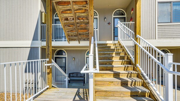 A wooden staircase leading to a balcony with white railings and a wooden ceiling. - Private Boat Slip: Family-Friendly Lazy Days Condo (Osage Beach)