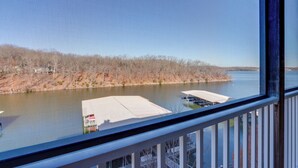 A view from a window overlooking a body of water with a dock and a building with a white roof. - Private Boat Slip: Family-Friendly Lazy Days Condo (Osage Beach)