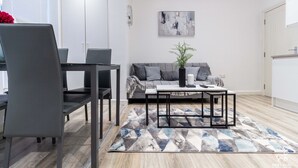 Een moderne woonkamer met een bank, salontafel en stoelen.