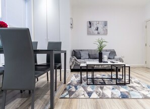 A modern living room with a sofa, coffee table, and chairs. - Watford WD18 - Contemporary 2 Bedroom/2 Bathroom Flat (Watford)