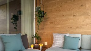 A modern living room with two grey sofas, a wooden coffee table, and a glass of wine.