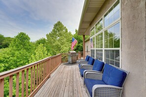Une terrasse en bois, meublée de mobilier en osier, et un drapeau américain.