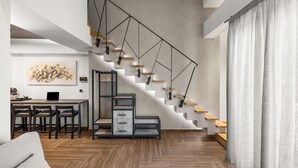 Ein modernes Interieur mit Treppe, Holzboden und Essbereich mit Laptop und Stühlen.