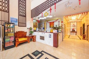 A hotel lobby with a reception desk, a seating area, and a decorative wall. - Antai Hotel (Anning)