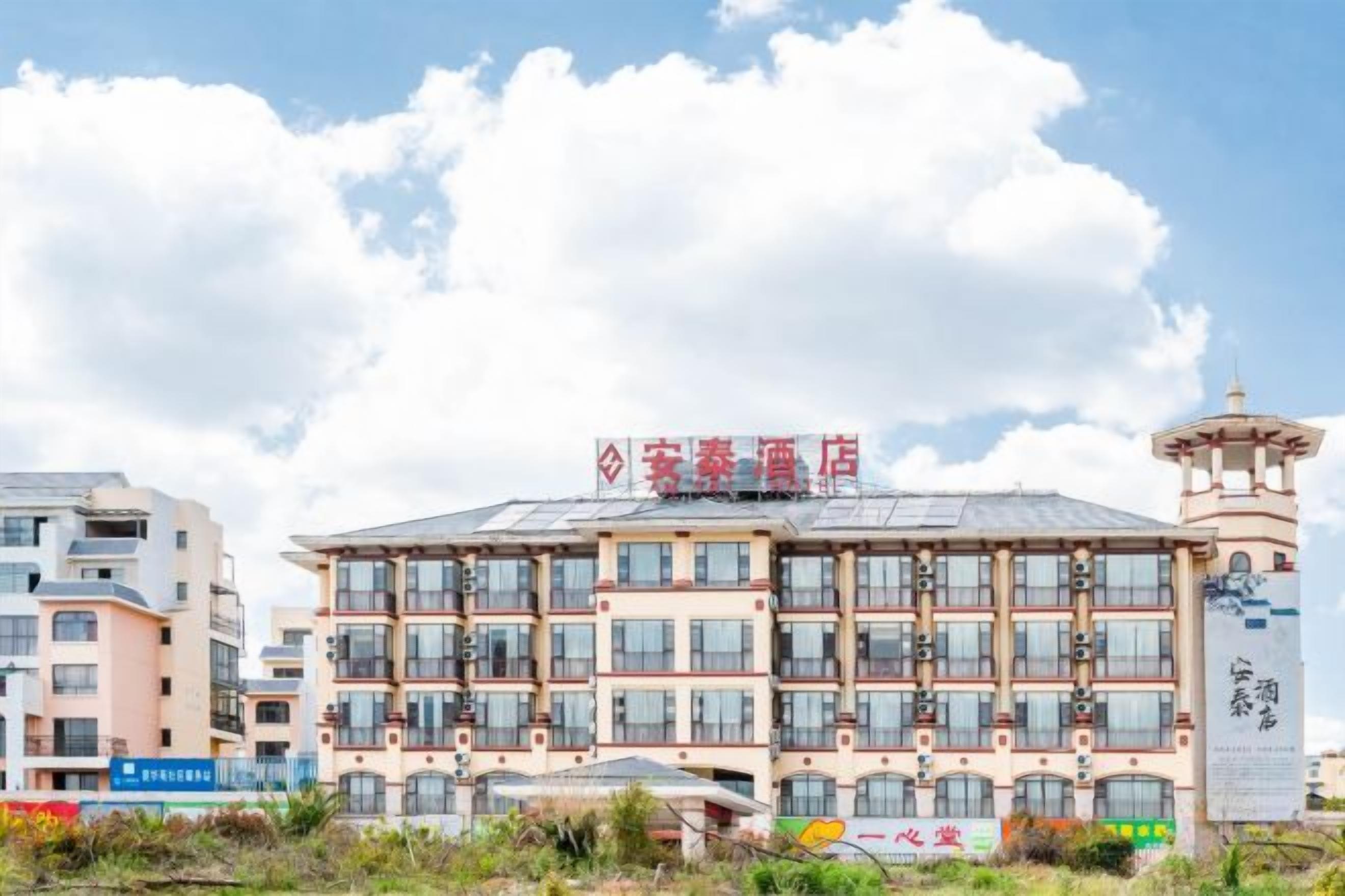 A multi-story hotel with a prominent sign, a tower-like structure on the right, and a clear sky.