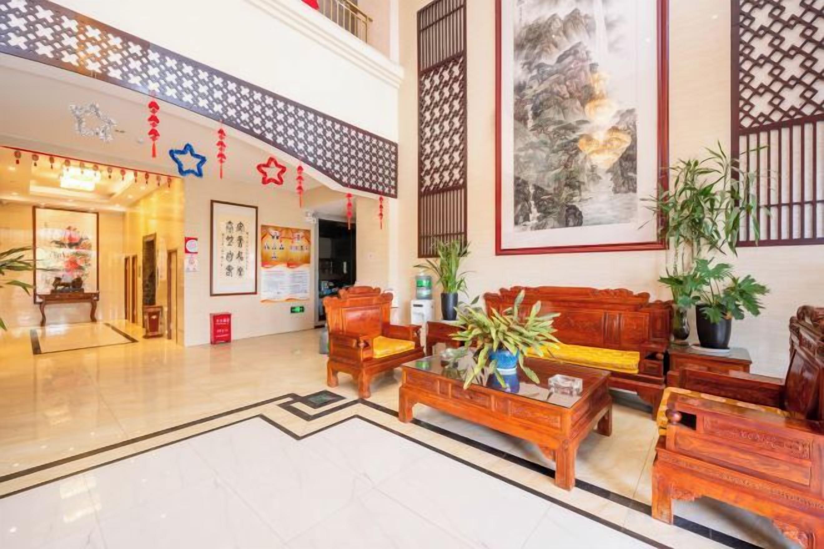 Un hall de hotel con mostrador de recepción, zona de estar y una obra de arte grande enmarcada en la pared.