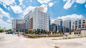 Un hôtel moderne à plusieurs étages, doté d’une cour intérieure et d’un parking.