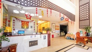 Un espace d’accueil doté d’un comptoir en marbre, de certificats encadrés et d’un paravent décoratif de style chinois traditionnel.