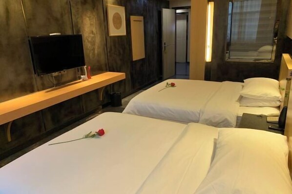 A hotel room with two beds, a TV, a wooden shelf, and a window. - Chenzhou Jiari Hotel (Chenzhou)