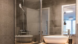 A modern bathroom with a glass-enclosed shower, a wooden vanity with a large vessel sink, and a mirror above the vanity. - BCAdria apartment Deluxe (Split)