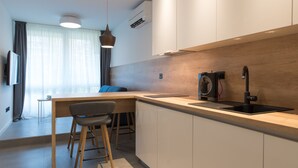 A modern kitchen with a wooden countertop, a built-in sink, and a bar area. - BCAdria apartment Deluxe (Split)