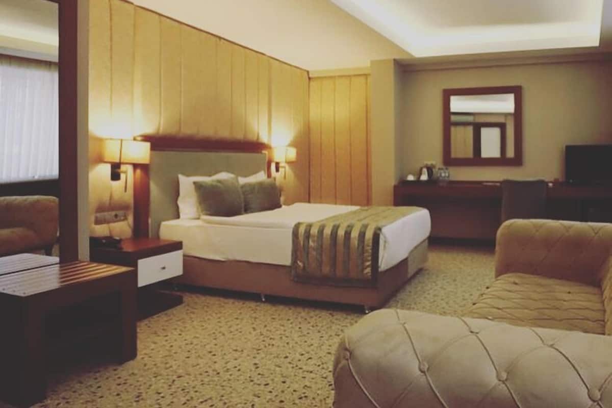 Classic hotel room with a large bed, bedside tables, and a flat-screen TV.