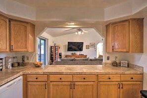 Enjoy cooking and relaxing in this well-appointed kitchen with dishwasher and ample storage, leading to a cozy living area with comfortable seating.