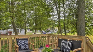 A wooden deck with a sofa and chairs, a table, and a potted plant with flowers. - Ocean View Escape ~ 4 Miles to Bethany Beach! (Ocean View)