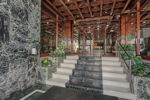 A grand staircase with marble steps leading to a wooden ceiling. - Unique beachfront apartment with spectacular sea views, pool, Wi-Fi, and terrace (Marbella)