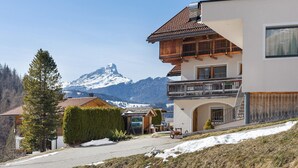 A two-story building with a balcony, a mountain view, and a snow-covered ground.