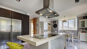 Una cocina moderna con una isla central, electrodomésticos de acero inoxidable y un comedor con vistas.