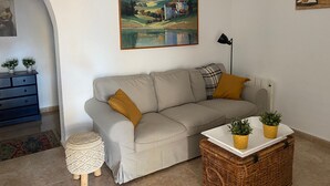 A living room with a sofa, a lamp, a laptop on a table, and a painting on the wall. - Villa Miantojo near the coast with Private Pool, Terrace, A/C & Wi-Fi. (Mazarrón)