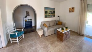 A living room with a sofa, armchair, and a ceiling fan. - Villa Miantojo near the coast with Private Pool, Terrace, A/C & Wi-Fi. (Mazarrón)