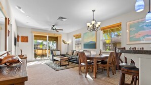 A spacious living area with a dining table, chairs, a sofa, and a fireplace. - 🏖️Garden View Waikoloa Condo w/ A/C + Ocean Club Access (Waikoloa)
