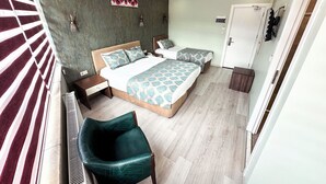 Um quarto com uma cama, duas mesas de cabeceira, uma cadeira, um radiador e um guarda-roupa.