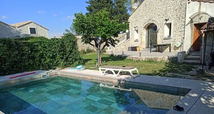 Maison en pierre rénovée dans un style contemporain avec jardin et piscine .