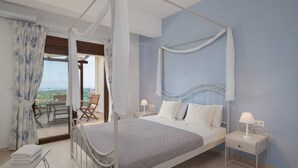 A bedroom with a four-poster bed, a nightstand with a lamp, and a view of the outdoors through a glass door.