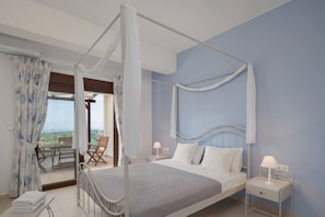 Une chambre à coucher avec un lit à baldaquin, une table de chevet avec une lampe et une vue sur l’extérieur grâce à une porte vitrée.